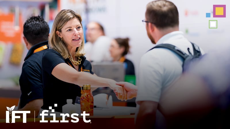Exhibitor shaking an attendee's hand at their booth at IFT FIRST.