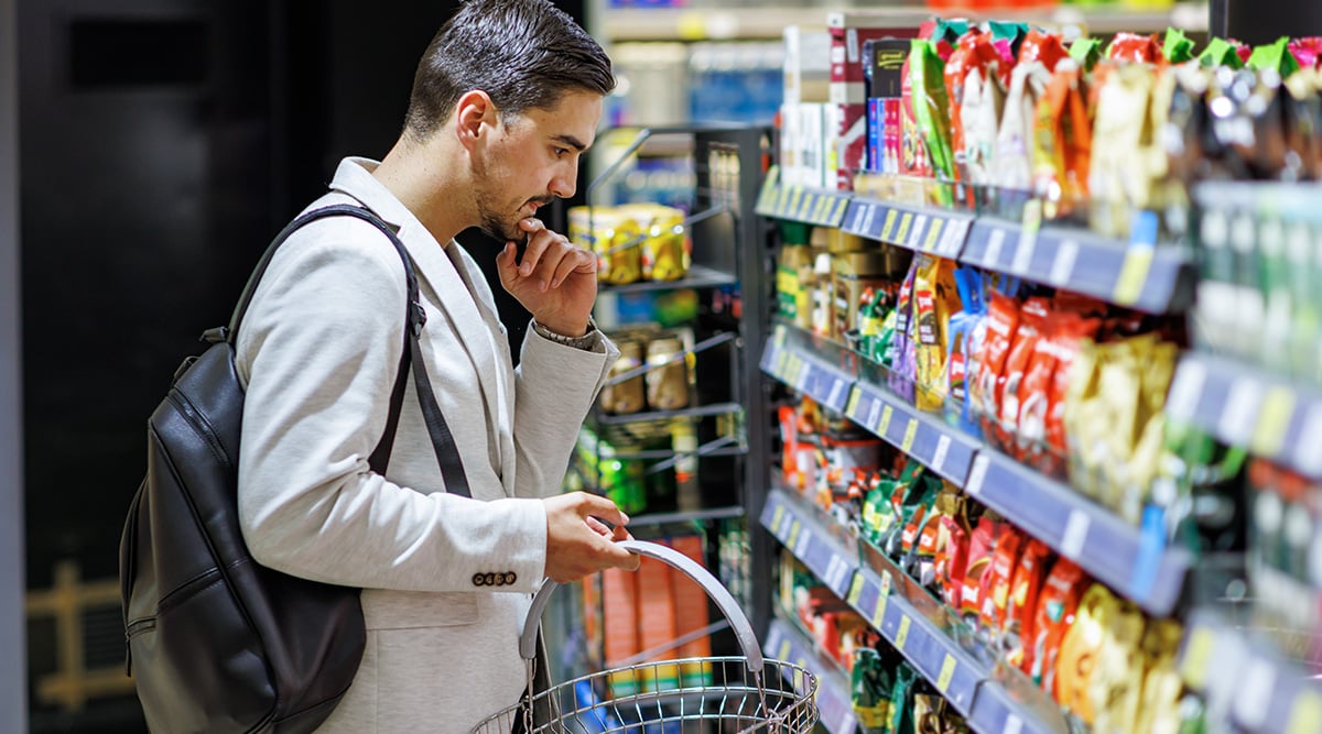 A man shops for food in a grocery aisle
