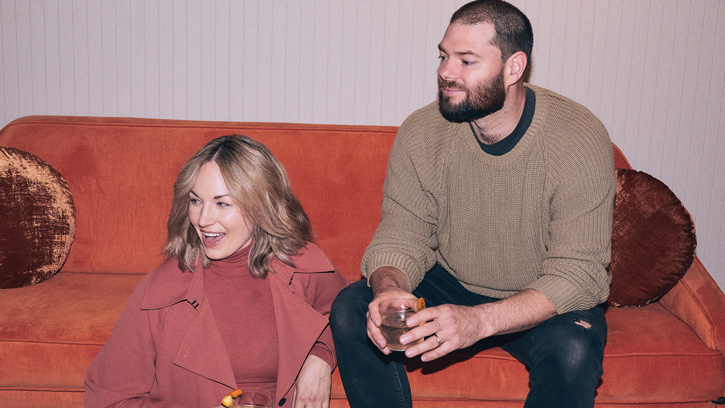 Adult and child sitting on red couch