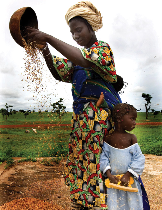 Farming woman pouring from bowl