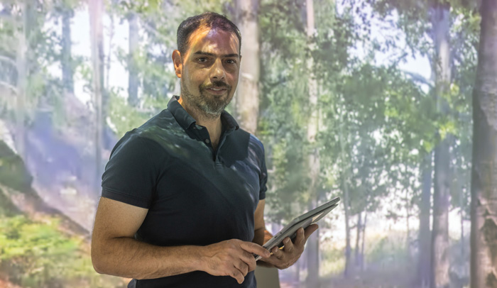 Julien Delarue of the University of California, Davis, stands in the university’s new sensory room designed to create an immersive research environment.