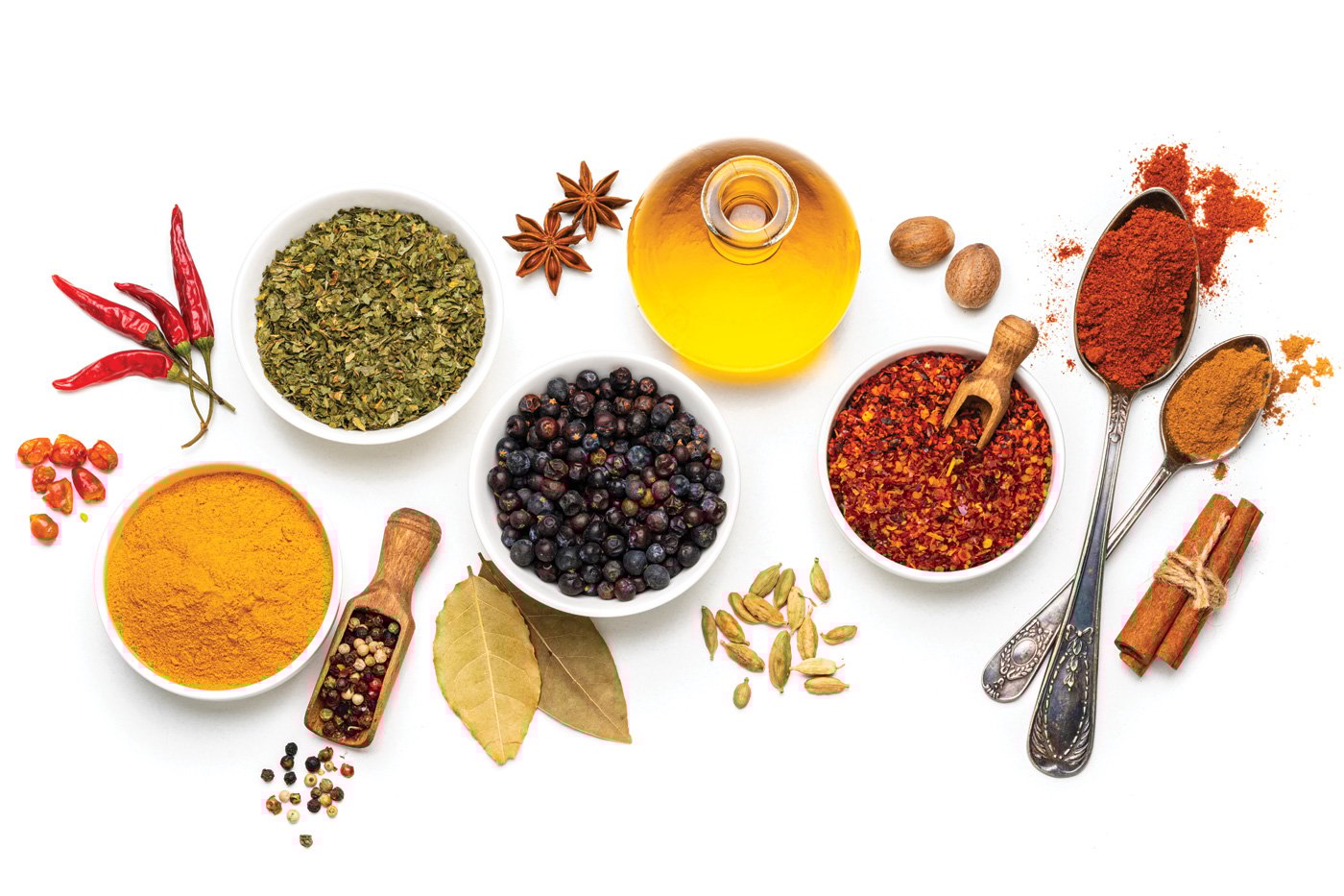 overhead view of several bowls and spoons with multicolored spices