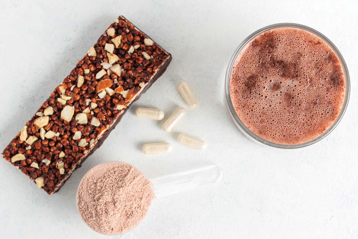 milkshake of whey protein isolate, protein powder in scoop, granola bar