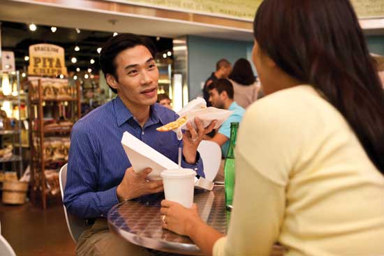 A patron enjoys a slice of pizza from WestRock’s EnShield pizza box. 