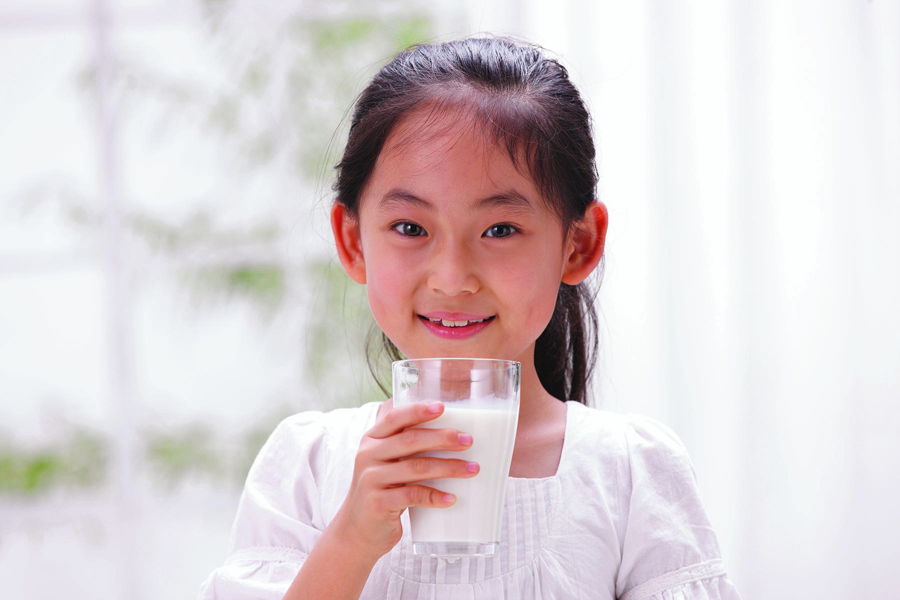 Young girl drinking glass of dairy